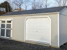 12x24 Peak Storage Shed. Light grey LP SmartSiding siding with white trim. Garage door and double door on a 24' side